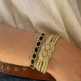 Pulsera Dunia, tejida a mano en Marruecos con hilo de oro s’fifa y seda de cactus. Diseño artesanal inspirado en la tradición de los caftanes nupciales, ligera, resistente al agua y perfecta para combinar entre sí. Una joya versátil que brilla con un toque sutil y elegante, pensada para acompañarte en cada momento.