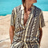 Hombre usando una camisa de rayón estampada en tonos beige y negro frente al mar, ideal para frescura y estilo.