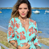 Arena Formentera vestido camisero bohemio en New Saari con flores rojas sobre fondo turquesa para mujer