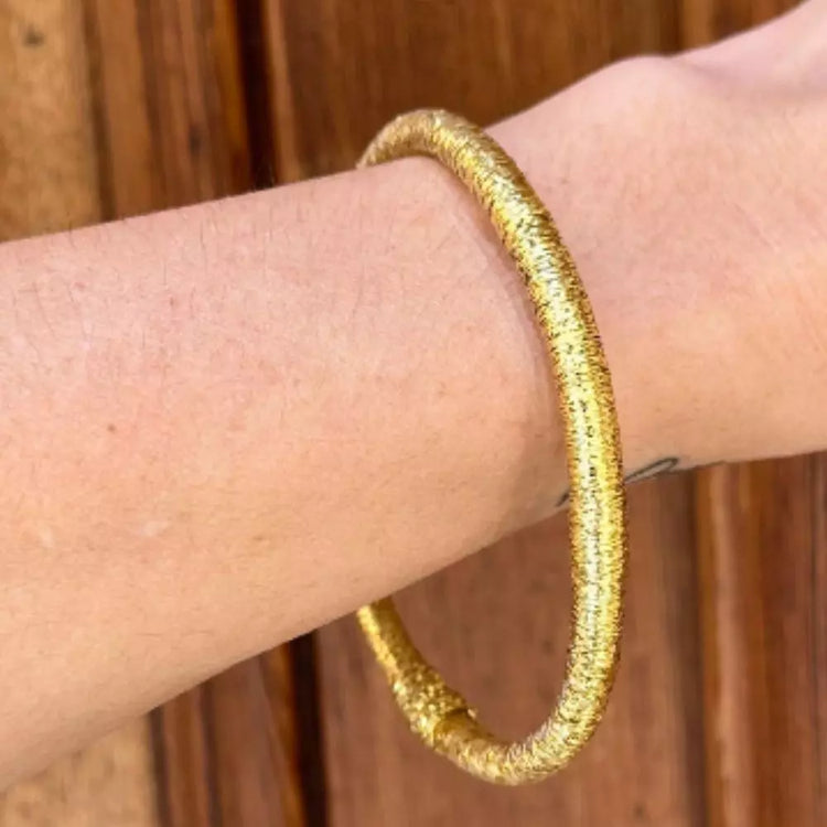 Pulsera Dunia, tejida a mano en Marruecos con hilo de oro s’fifa y seda de cactus. Diseño artesanal inspirado en la tradición de los caftanes nupciales, ligera, resistente al agua y perfecta para combinar entre sí. Una joya versátil que brilla con un toque sutil y elegante, pensada para acompañarte en cada momento.