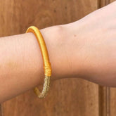 Pulsera Dunia, tejida a mano en Marruecos con hilo de oro s’fifa y seda de cactus. Diseño artesanal inspirado en la tradición de los caftanes nupciales, ligera, resistente al agua y perfecta para combinar entre sí. Una joya versátil que brilla con un toque sutil y elegante, pensada para acompañarte en cada momento.