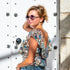 Mujer luciendo un top corto bohemio con volantes, gafas de sol y estilo veranvergente.