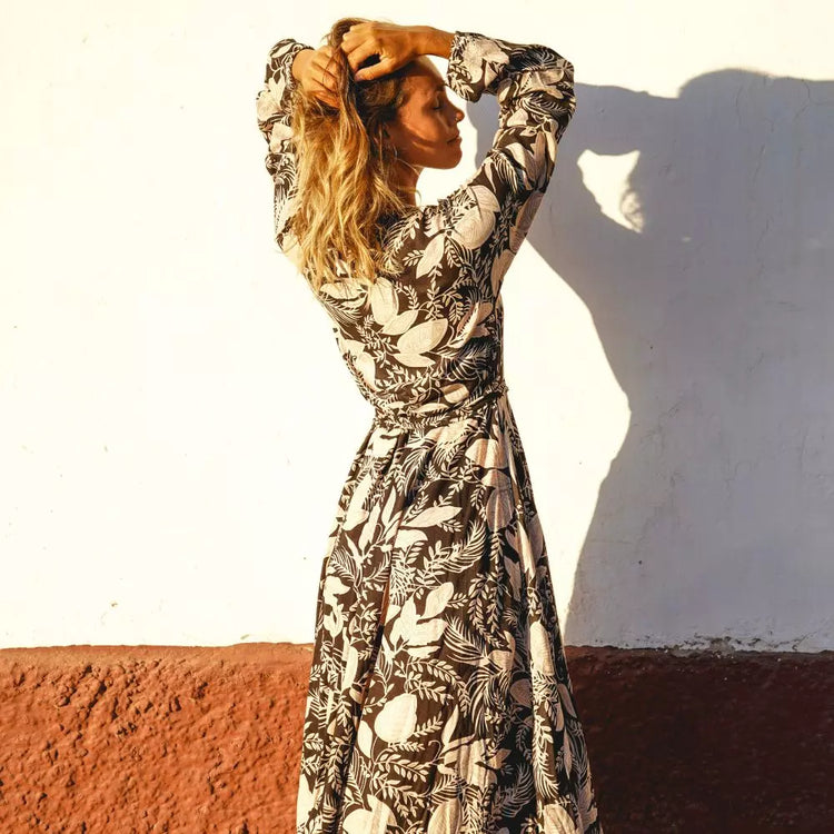 Arena Formentera vestido largo bohemio cruzado en New Saari con estampado botánico en tonos negro y beige, estilo elegante y veraniego para mujer