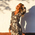 Arena Formentera vestido largo bohemio cruzado en New Saari con estampado botánico en tonos negro y beige, estilo elegante y veraniego para mujer