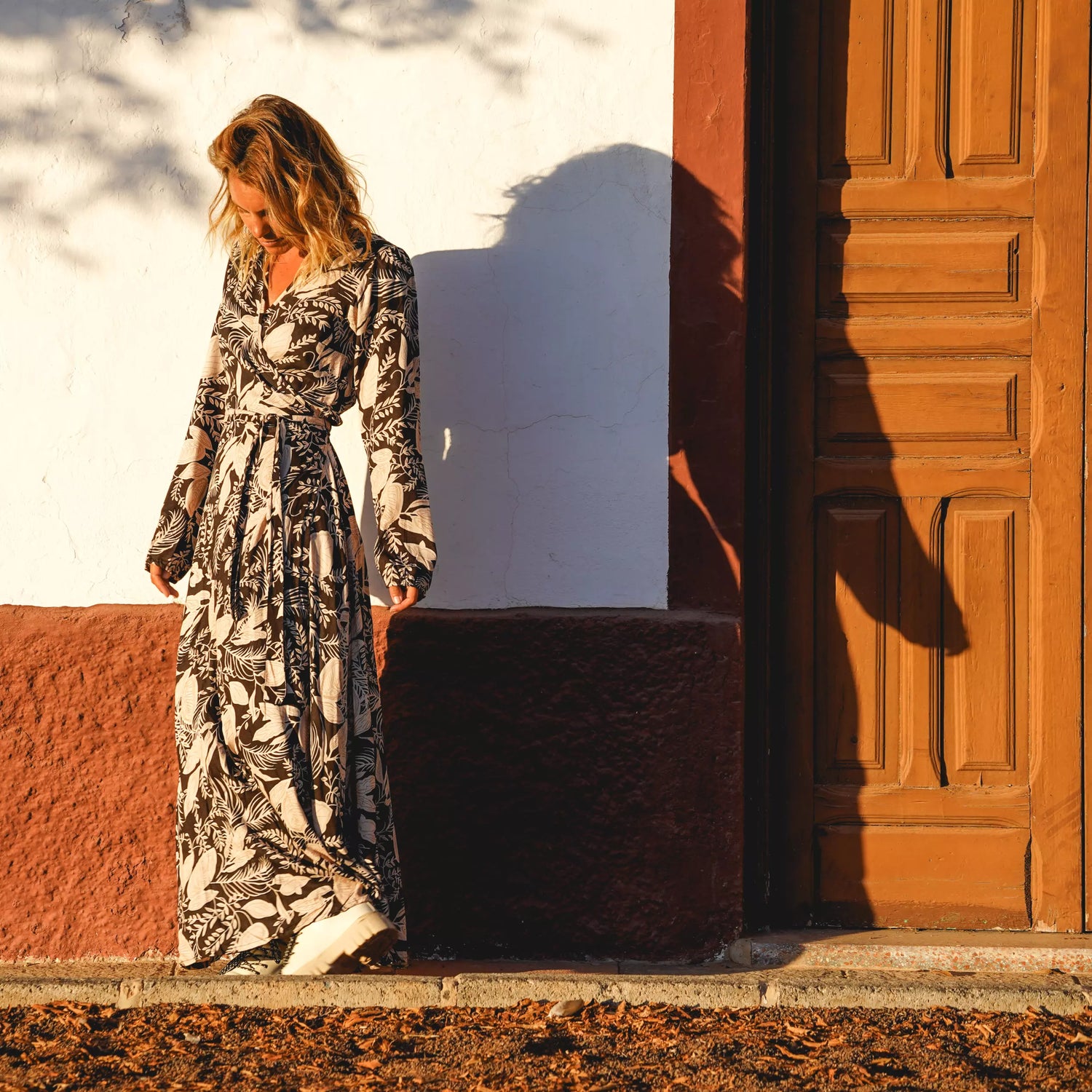 Arena Formentera vestido largo bohemio cruzado en New Saari con estampado botánico en tonos negro y beige, estilo elegante y veraniego para mujer